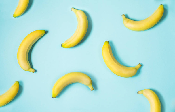 Top view of fresh yellow bananas isolated on blue background - Zdjęcie, obraz