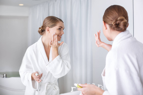 Cheerful young woman undergoing skincare treatment - Photo, Image