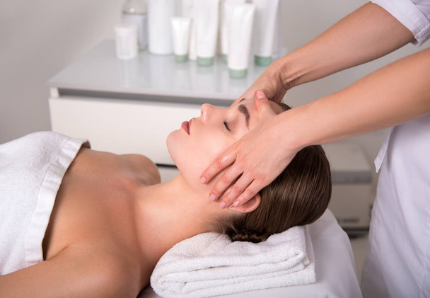 Skillful beautician massaging female face - Photo, Image