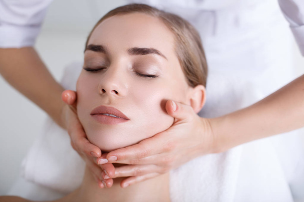 Relaxed girl getting facial massage at spa - Photo, image