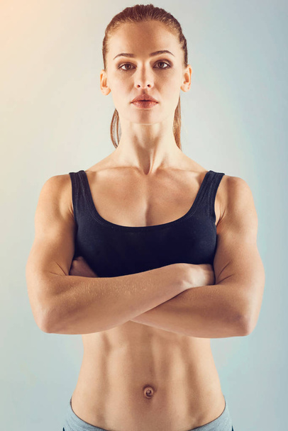 Confident female athlete standing with arms crossed - Fotoğraf, Görsel