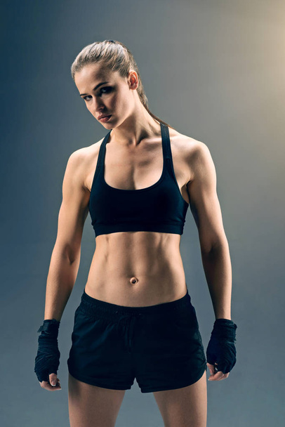 Strong female boxer looking into camera confidently - Fotografie, Obrázek