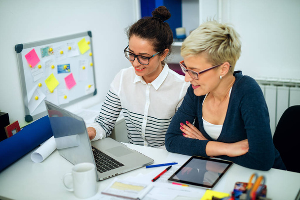 portrait de femmes heureuses professionnelles ayant une réunion au bureau et utilisant un ordinateur portable
  - Photo, image