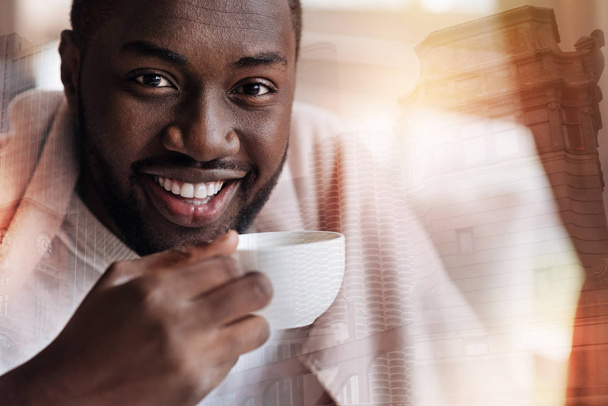 Pleasant young man feeling relaxed while drinking tea - Foto, Imagem