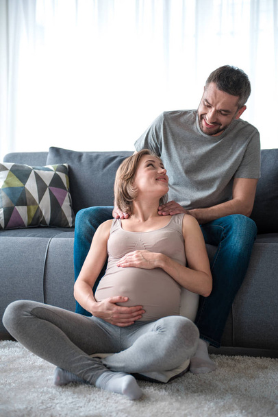 Glad man doing massage for expectant mother at home - Photo, image