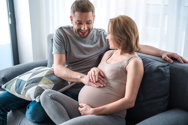 Happy husband feeling heartbeat of his unborn child - Valokuva, kuva