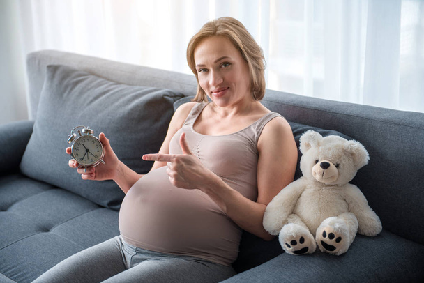 Glad expectant mother showing time of last trimester - Valokuva, kuva