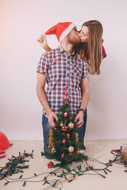 loving couple decorating Christmas tree - Фото, изображение