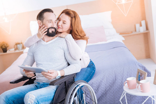 Inspired woman caressing a crippled man - Foto, imagen