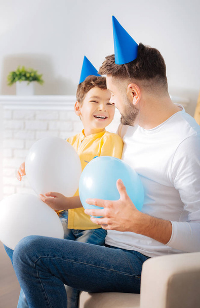vader en zoon houden ballonnen en lachen - Foto, afbeelding