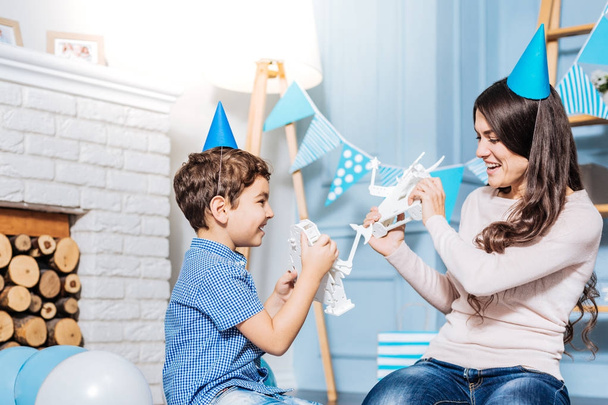 Cheerful son and mother fighting with toy robots - Fotoğraf, Görsel