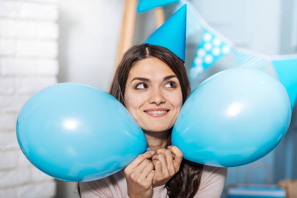 Happy woman holding two balloons near her face - Fotoğraf, Görsel
