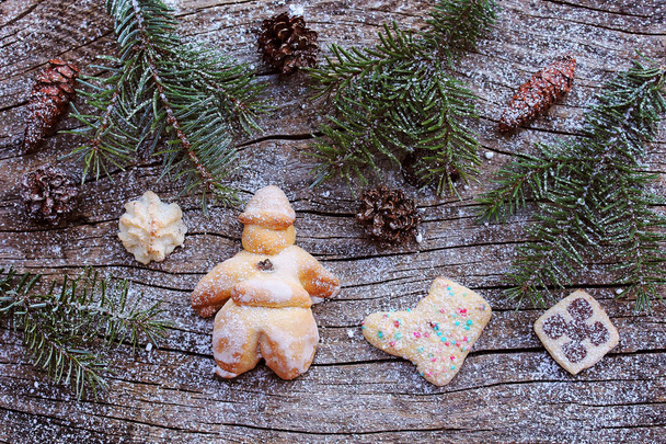 Un Santa Claus y galletas de masa. Decoración de Navidad sobre sustrato de madera
 - Foto, Imagen