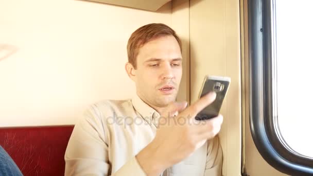 A person uses a smartphone in a compartment of a passenger train. 4k - Felvétel, videó