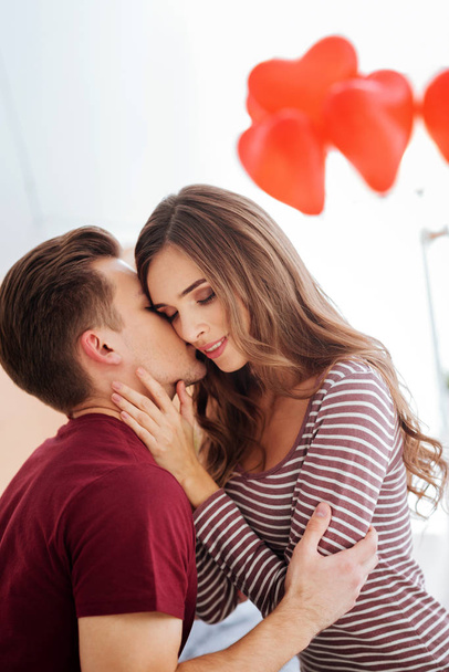 Любящий молодой человек целует свою девушку
 - Фото, изображение