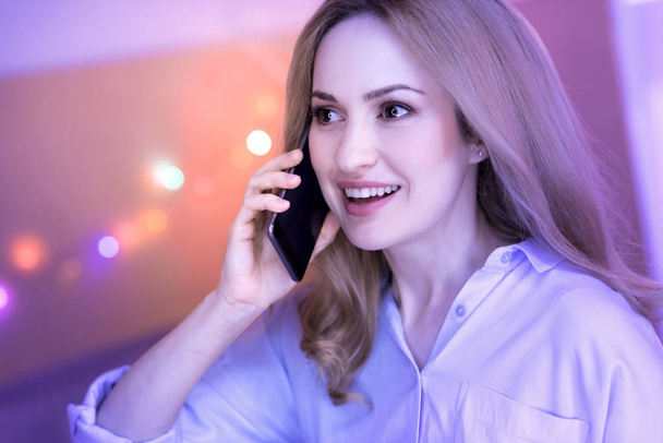 Smiling woman having a conversation on the phone - Фото, изображение