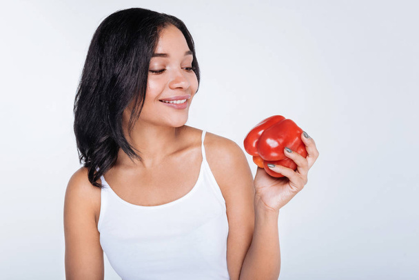 woman looking at red bell pepper - Foto, imagen
