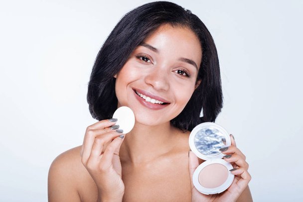  woman showing her powder with a puff - Photo, Image