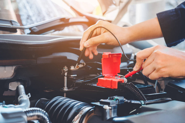 Mãos verificar bateria carro mecânico trabalhando no serviço de reparação de automóveis
 - Foto, Imagem