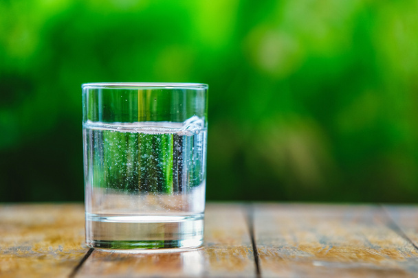 Un vaso de agua sobre fondo verde
 - Foto, Imagen