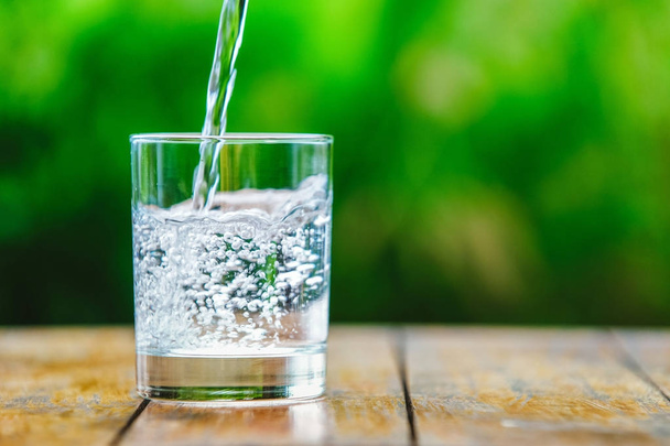 A glass of water on green background - Photo, Image