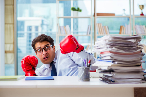 Empresario con guantes de boxeo en la oficina - Foto, imagen