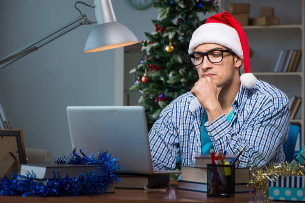 Young man working at home on christmas day - Photo, Image