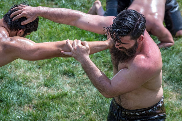 Unidentified Turkish people perform oil wrestling.Oil wrestling or grease wrestling (Yagli Gures) is Turkish national sport.ISTANBUL,TURKEY,May 13,2017 - Foto, Imagen