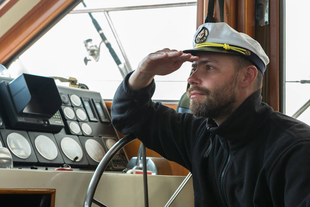 Captain at the helm of boat going along the Pacific Ocean - Foto, afbeelding