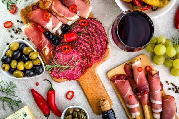 Table with food, selection tapas bar, meat and wine glass, mediterranean diet - Фото, изображение