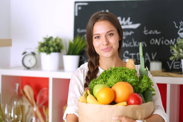 Young woman holding grocery shopping bag with vegetables. Young woman - Foto, Imagem