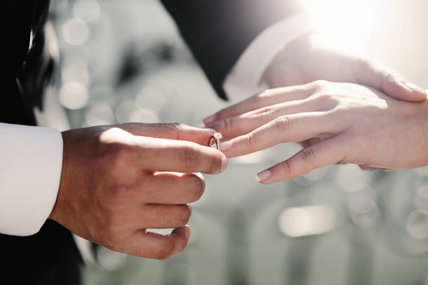 bride and groom holding golden wedding rings  - Фото, изображение