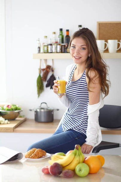Young woman standing near desk in the kitchen. Young woman . - Foto, afbeelding