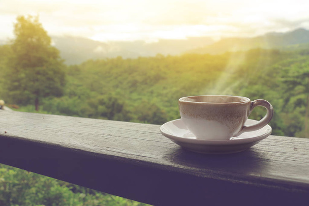 φλιτζάνι καφέ στο μπαλκόνι ξύλο το πρωί με θέα στο βουνό. - Φωτογραφία, εικόνα