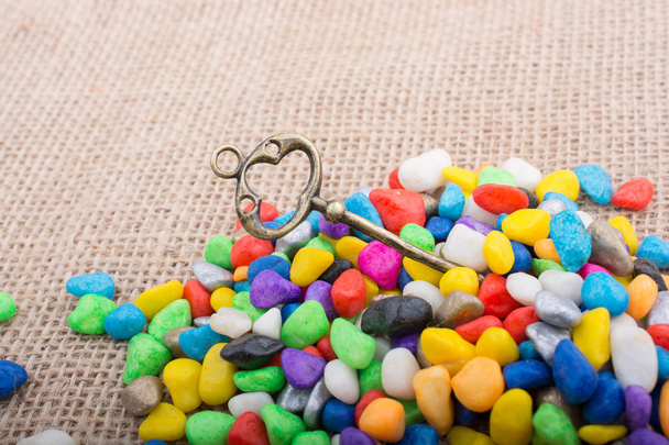 Little retro key amid colorful pebbles  - Photo, Image