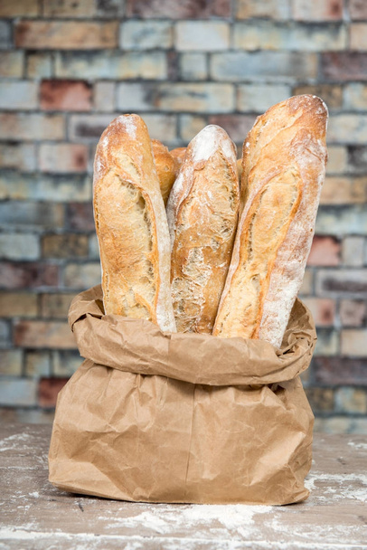 Fresh baked rustic bread loaves in paper bags - Foto, Bild