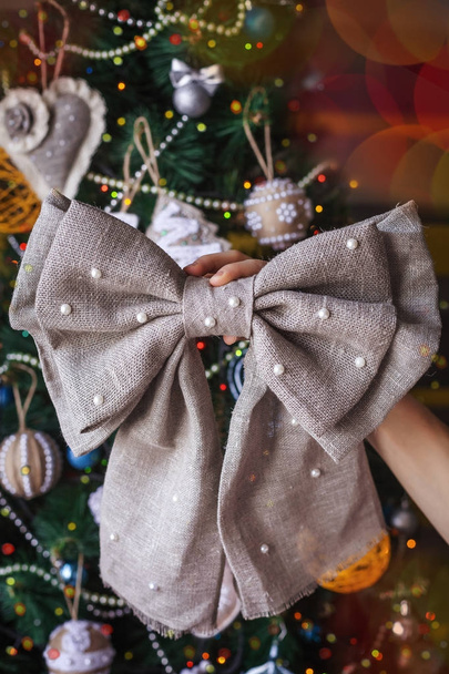 hands with new year handmade sackcloth bow - Fotografie, Obrázek