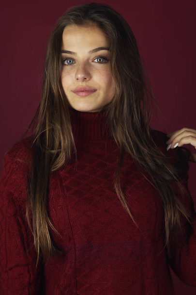 Beautiful fashion woman wearing a red sweater on a red background  - Fotografie, Obrázek