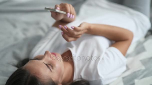 Pleasant young woman using her smartphone in the morning - Кадры, видео