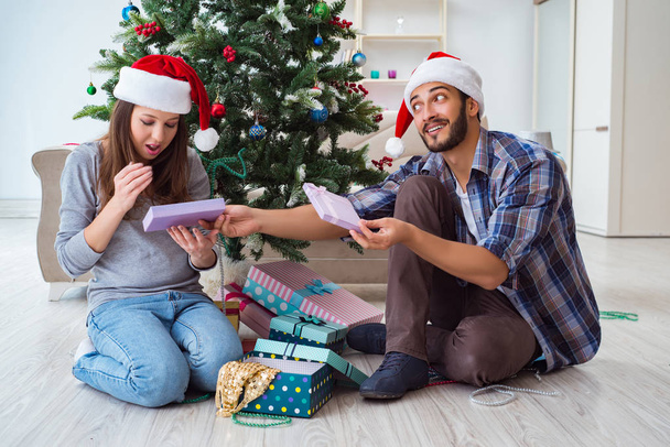 Подруга і хлопець відкривають різдвяні подарунки
 - Фото, зображення