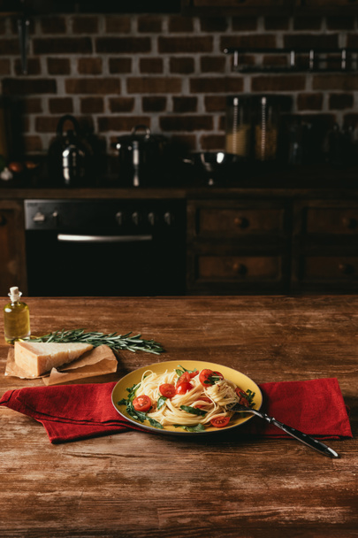 perinteinen italialainen pasta tomaattien ja arugulan kanssa pöydällä parmesaanilla ja rosmariinilla
 - Valokuva, kuva