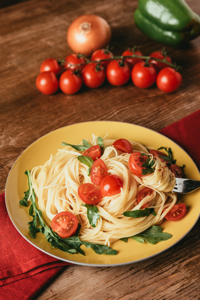 delicious italian pasta with tomatoes and arugula in plate - Photo, Image