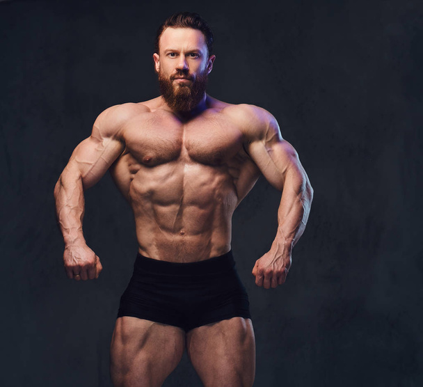 Ritratto di bodybuilder barbuto senza maglietta su sfondo grigio
. - Foto, immagini