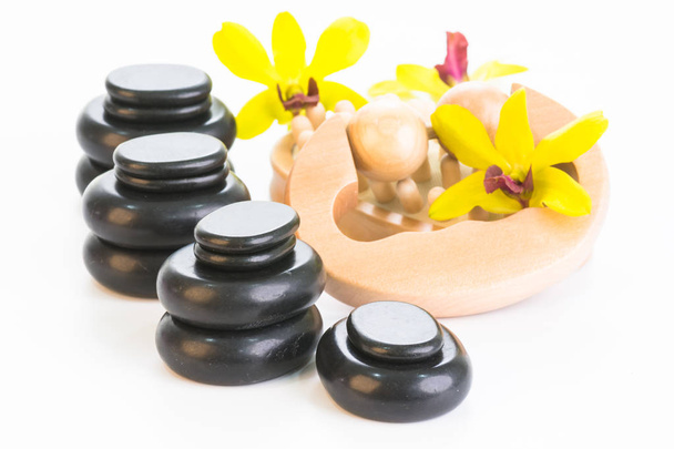 Spa concept met hete stenen, massage roller, cellulitis massage en orchideeën close-up - Foto, afbeelding