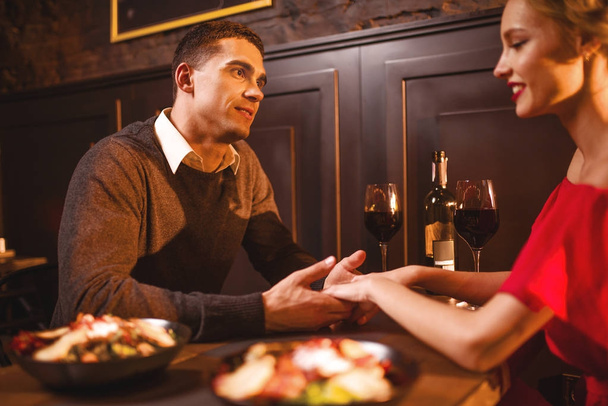 Casal de amor jovem no restaurante, encontro romântico. Mulher elegante em vestido vermelho e jantar bonito homem
  - Foto, Imagem