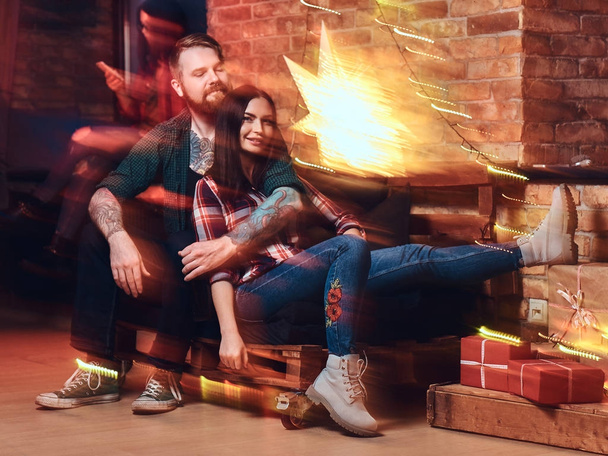 One bearded male and two brunette women Christmas party in a room with loft interior. - Photo, Image