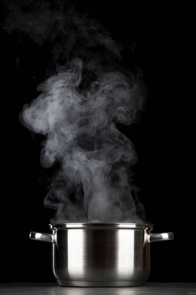 Steaming pot on black background - Photo, Image