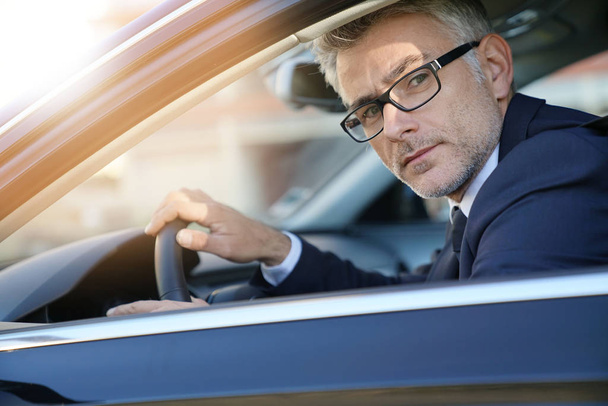 Portrait of businessman driving car for work - Foto, Bild