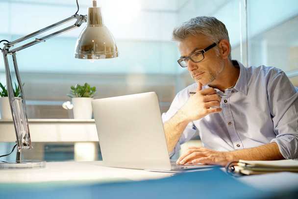 Businessman working in office with laptop computer - Φωτογραφία, εικόνα
