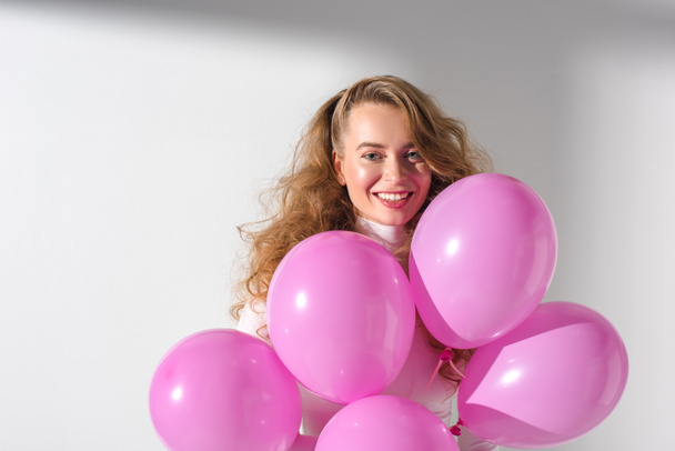 piękna dziewczyna uśmiechający się w dzięki zestawowi różowy balony - Zdjęcie, obraz